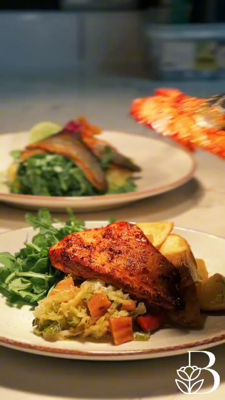 Two plated dishes of fish and greens at The BlackHeath House